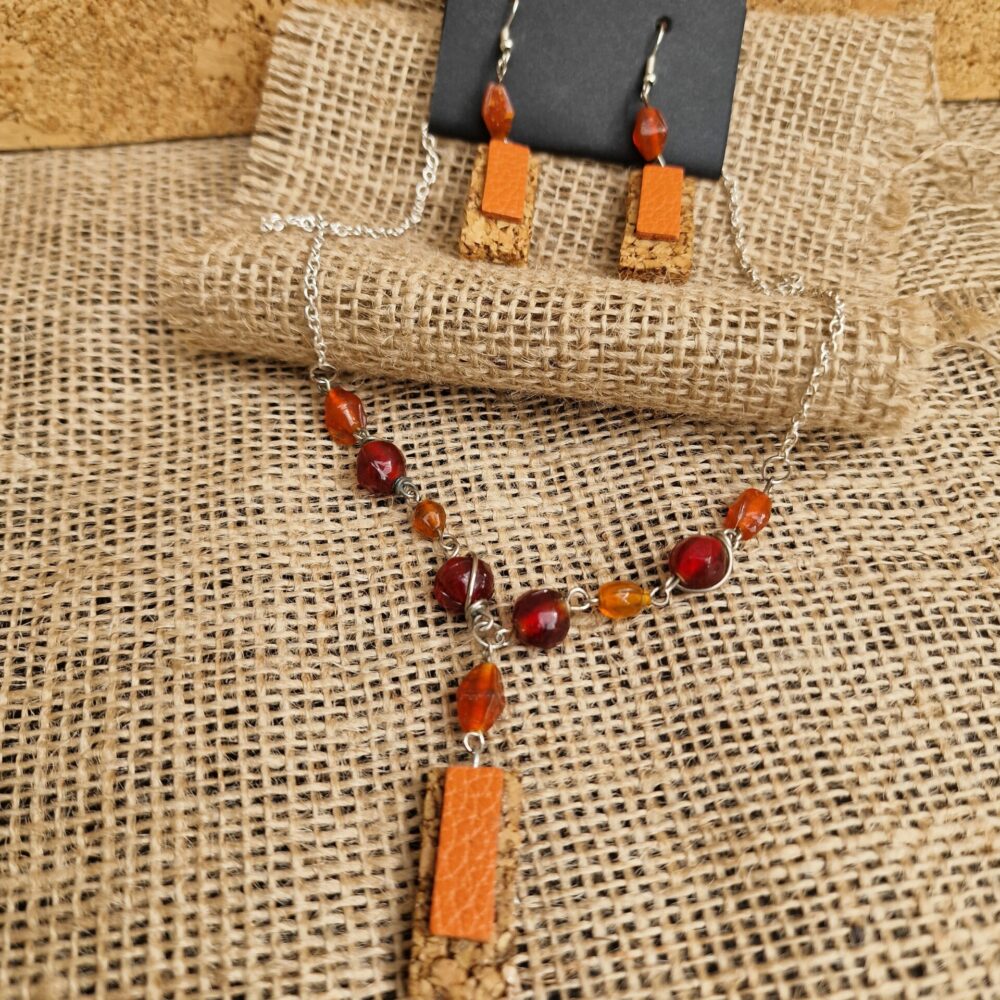 Parure artisanale composée d’un collier et de boucles d’oreilles en liège et cuir orange, perles rouges et ambrées, attaches argentées