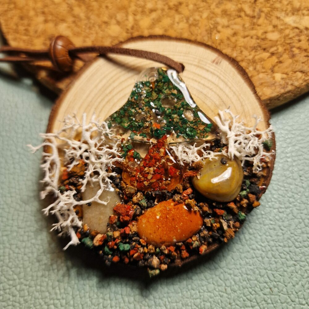 Petit champignon artisanal en résine avec inclusions de liège, cailloux et mousse blanchie sur rondin de bois, avec attache en cuir et perle en bois – création Cé’rénité