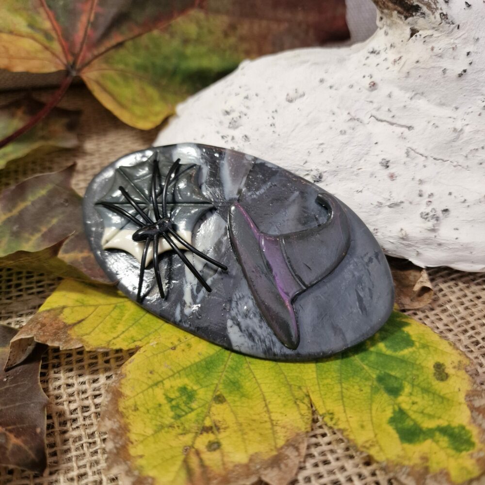 Pince à cheveux artisanale Cé’rénité en pâte polymère noire et grise, décor toile et araignée argentée, longueur 10 cm, création d’inspiration Halloween.