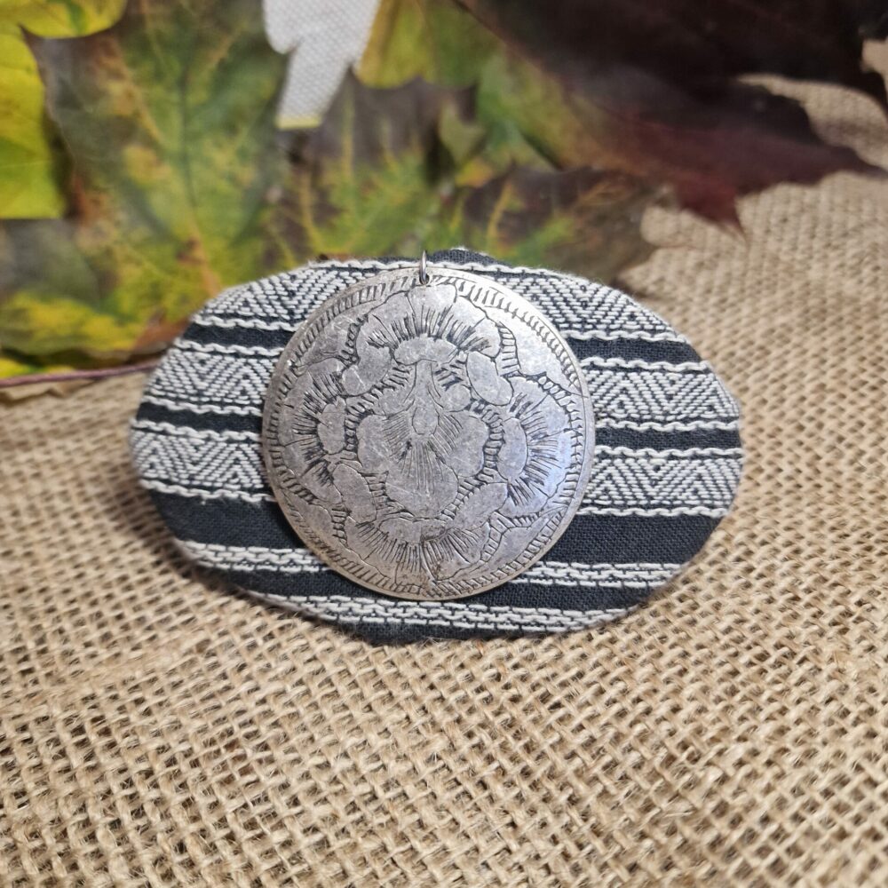 Pince à cheveux artisanale en tissu gris rayé, décorée d’une breloque argentée