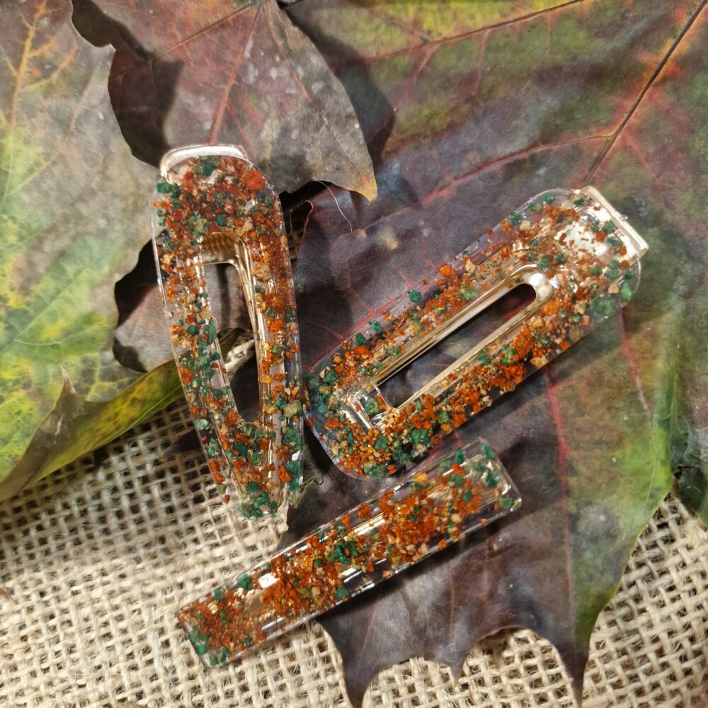 Ensemble de trois barrettes artisanales en résine transparente, inclusions de liège et éclats vert et rouge, attaches dorées