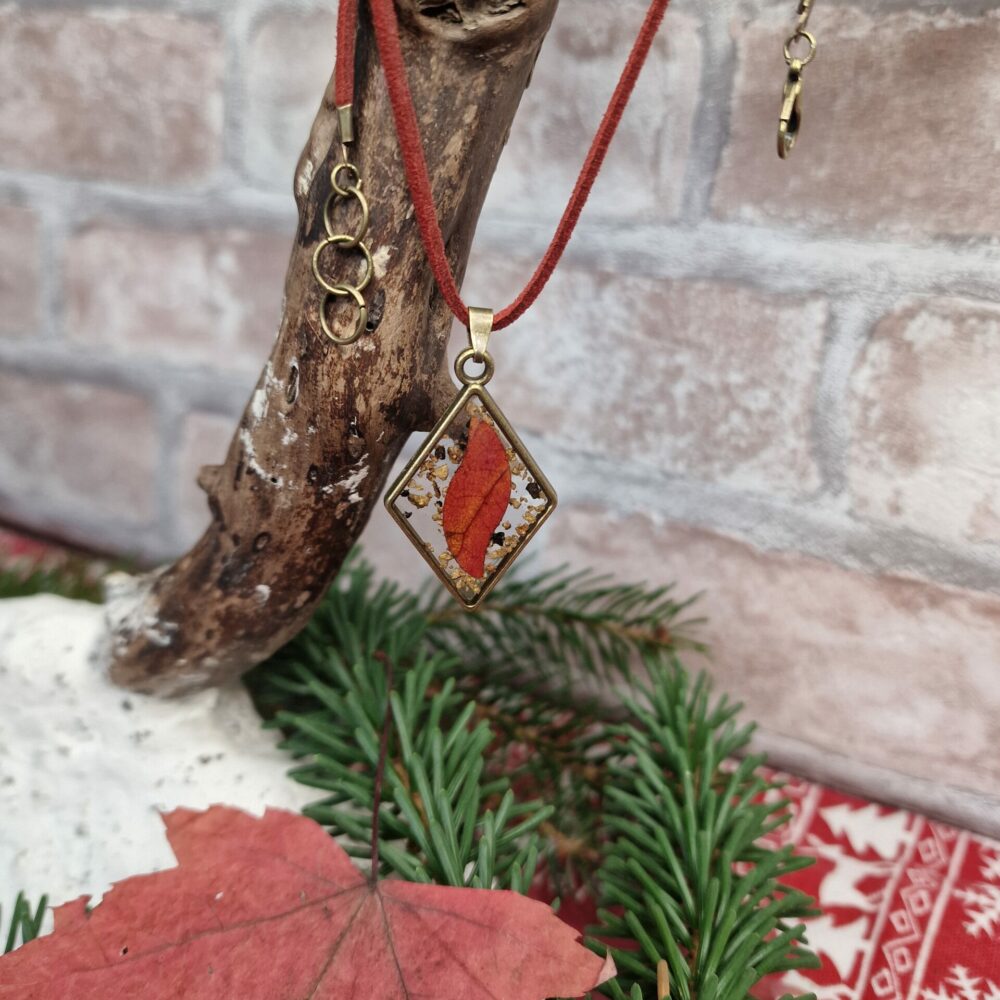 Collier artisanal Cé’rénité en résine transparente avec feuille naturelle et liège, pendentif losange bronze sur cordon simili cuir rouge.