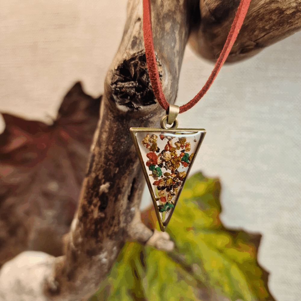 Collier artisanal Cé’rénité en résine transparente et liège naturel rouge et vert, pendentif triangle bronze monté sur cordon simili cuir rouge.